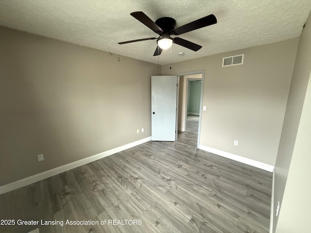 1512 Lindy Dr, Lansing, MI 48917 - unfurnished room with a textured ceiling, wood finished floors, baseboards, and a ceiling fan