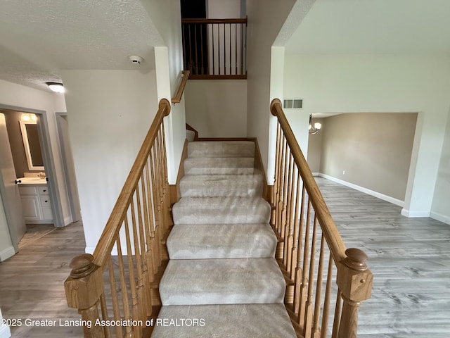 1512 Lindy Dr, Lansing, MI 48917 - stairway with wood finished floors, baseboards, and a textured ceiling