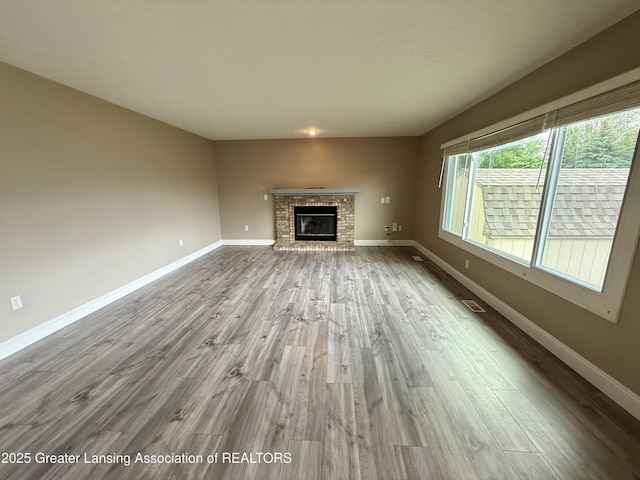 1512 Lindy Dr, Lansing, MI 48917 - unfurnished living room with wood finished floors, a fireplace, and baseboards