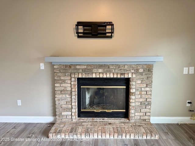 1512 Lindy Dr, Lansing, MI 48917 - detailed view of wood finished floors, baseboards, and a brick fireplace