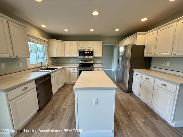 1512 Lindy Dr, Lansing, MI 48917 - kitchen featuring appliances with stainless steel finishes, a sink, a center island, white cabinetry, and light wood-type flooring