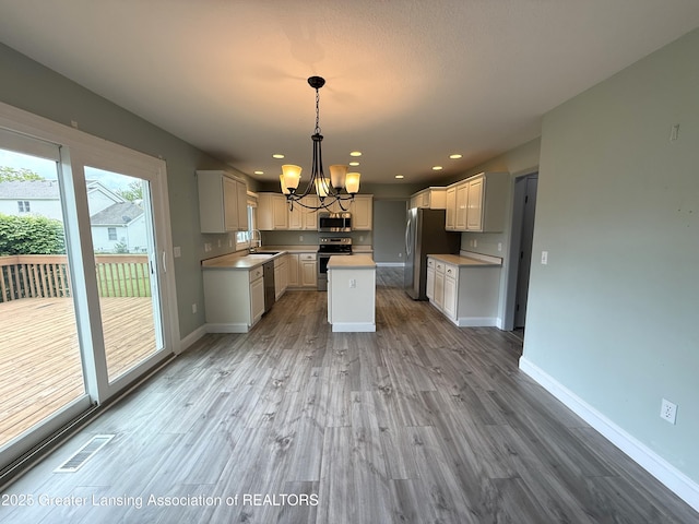 1512 Lindy Dr, Lansing, MI 48917 - kitchen with appliances with stainless steel finishes, a chandelier, a sink, light wood-type flooring, and light countertops