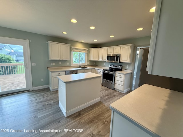 1512 Lindy Dr, Lansing, MI 48917 - kitchen with stainless steel appliances, white cabinets, light wood-style flooring, recessed lighting, and light countertops