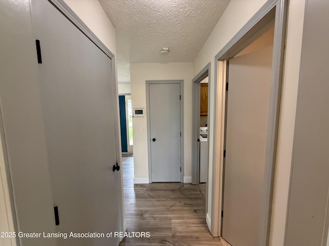 1512 Lindy Dr, Lansing, MI 48917 - corridor featuring light wood-type flooring, a textured ceiling, and baseboards