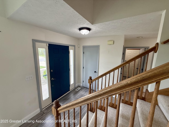 1512 Lindy Dr, Lansing, MI 48917 - foyer entrance with baseboards, dark wood-type flooring, stairs, and a textured ceiling