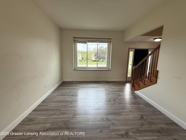 1512 Lindy Dr, Lansing, MI 48917 - unfurnished room featuring stairs, wood finished floors, and baseboards