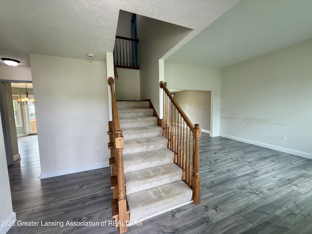 1512 Lindy Dr, Lansing, MI 48917 - stairway with a chandelier, wood finished floors, baseboards, and a textured ceiling