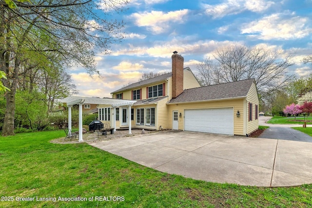 4767 Mohican Ln, Okemos, MI 48864 - back of property featuring a pergola, an attached garage, a chimney, a lawn, and concrete driveway