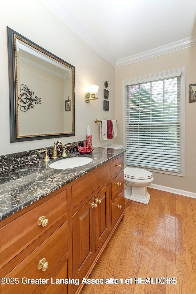 4767 Mohican Ln, Okemos, MI 48864 - half bath with toilet, crown molding, vanity, wood finished floors, and baseboards