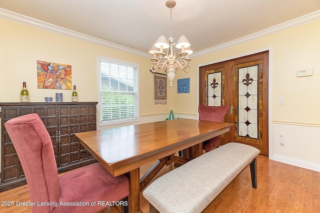 4767 Mohican Ln, Okemos, MI 48864 - dining room featuring a chandelier, ornamental molding, light wood-type flooring, and baseboards