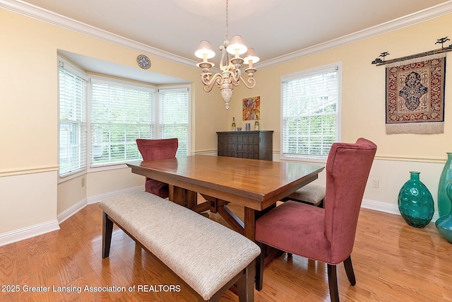 4767 Mohican Ln, Okemos, MI 48864 - dining area featuring light wood-style flooring, a chandelier, crown molding, and baseboards