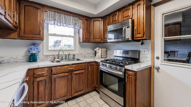 515 Chanticleer Trl, Lansing, MI 48917 - kitchen featuring appliances with stainless steel finishes, a sink, light countertops, and backsplash