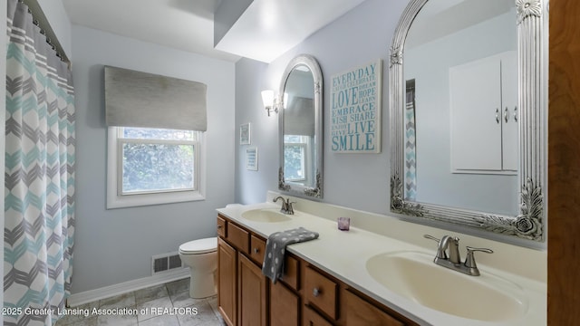 515 Chanticleer Trl, Lansing, MI 48917 - bathroom with double vanity, toilet, and baseboards