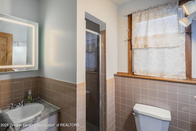 515 Chanticleer Trl, Lansing, MI 48917 - bathroom with tile walls, a shower stall, toilet, vanity, and a wainscoted wall