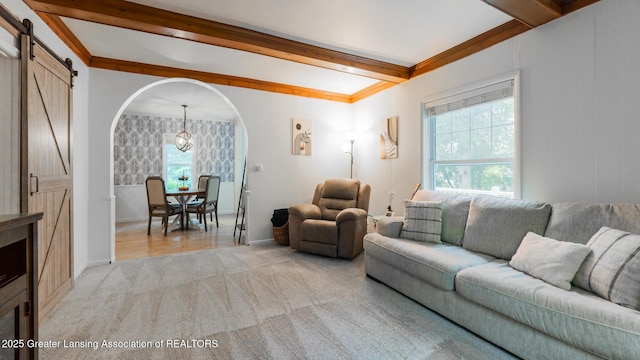 9181 Coleman Rd, Haslett, MI 48840 - living room featuring a barn door, beamed ceiling, light colored carpet, baseboards, and arched walkways