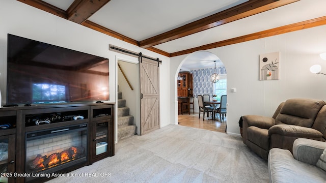 9181 Coleman Rd, Haslett, MI 48840 - living area featuring arched walkways, beamed ceiling, a barn door, light colored carpet, and stairway