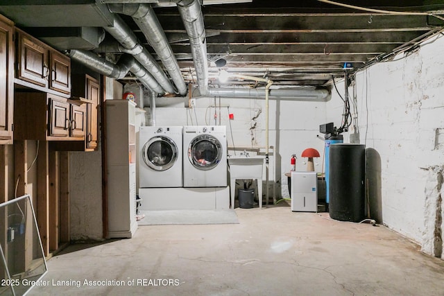 9181 Coleman Rd, Haslett, MI 48840 - unfinished below grade area featuring washer and dryer, a water softener system, and a sink