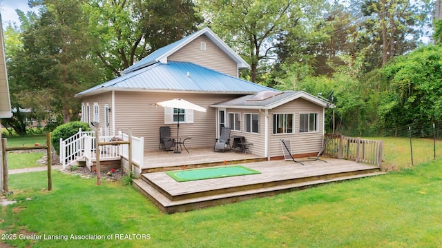 9181 Coleman Rd, Haslett, MI 48840 - rear view of property with a deck, a lawn, and metal roof