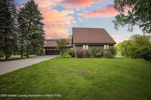 12560 Eaton Rapids Rd, Springport, MI 49284 - mid-century home with a garage, a front yard, driveway, and a shingled roof