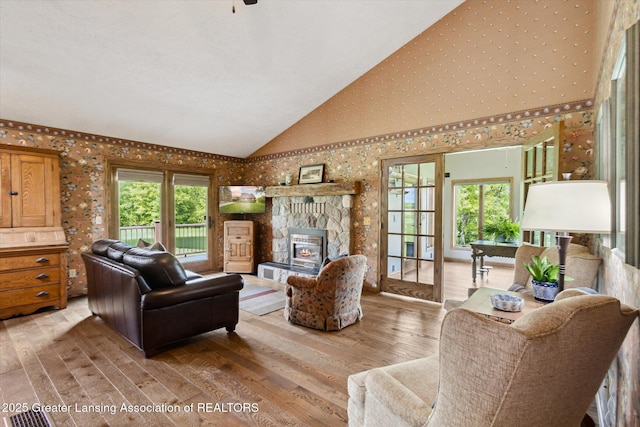 12560 Eaton Rapids Rd, Springport, MI 49284 - living area featuring wallpapered walls, light wood-type flooring, high vaulted ceiling, and a fireplace