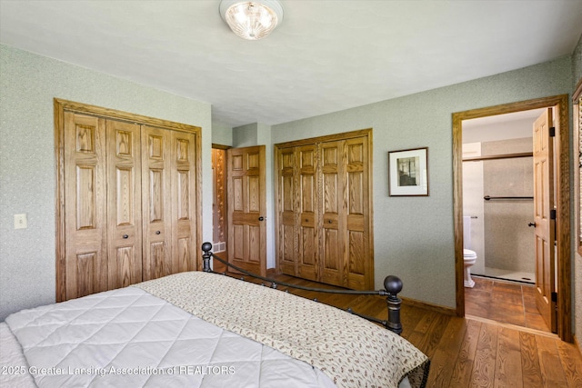 12560 Eaton Rapids Rd, Springport, MI 49284 - bedroom featuring wood finished floors, baseboards, ensuite bath, a textured wall, and two closets