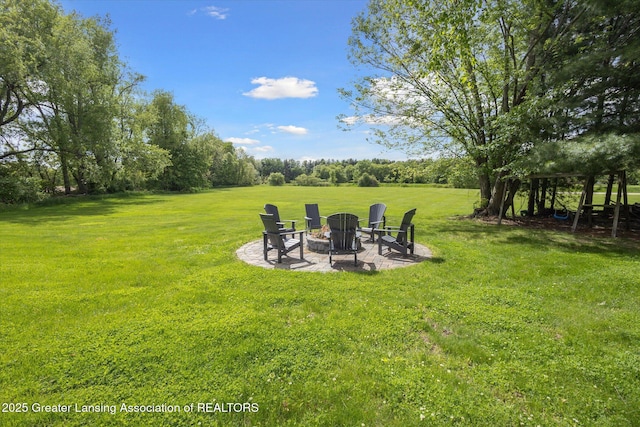 12560 Eaton Rapids Rd, Springport, MI 49284 - view of green lawn featuring an outdoor fire pit and a patio area