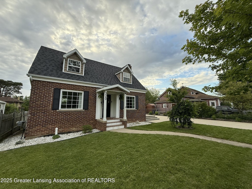 320 Elm St, Portland, MI 48875 - cape cod home featuring brick siding and roof with shingles
