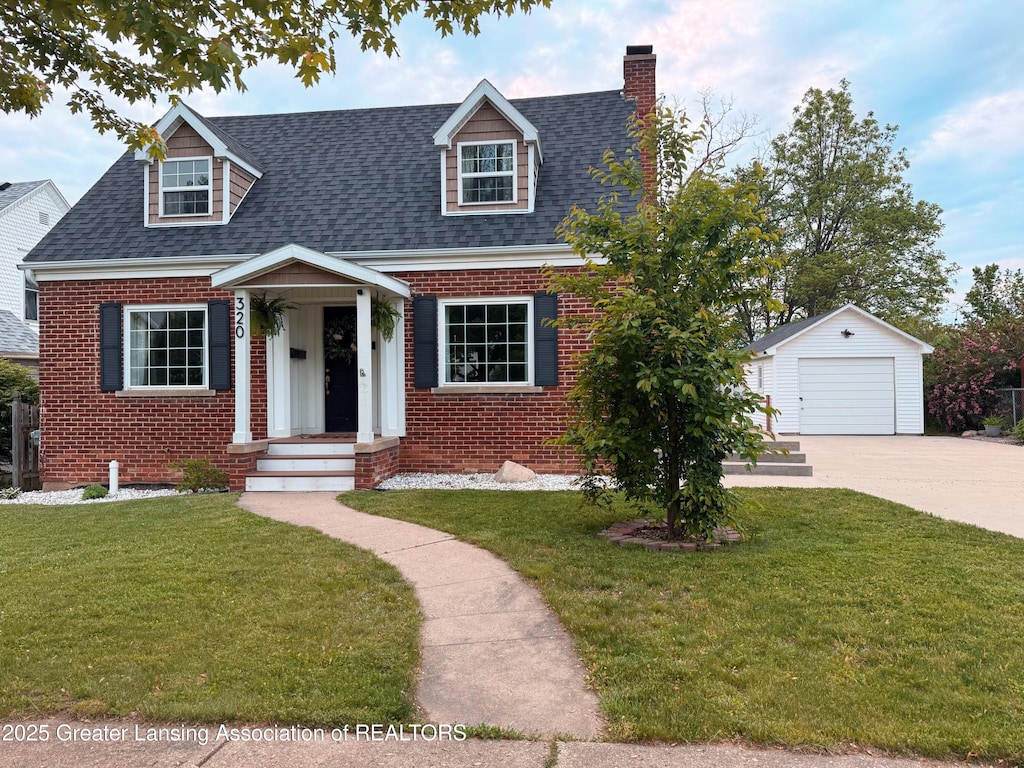 320 Elm St, Portland, MI 48875 - cape cod-style house featuring brick siding, an outbuilding, driveway, and a chimney