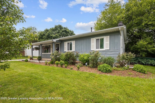 530 S Dibble Blvd, Lansing, MI 48917 - view of front of house featuring a chimney, board and batten siding, and a front yard