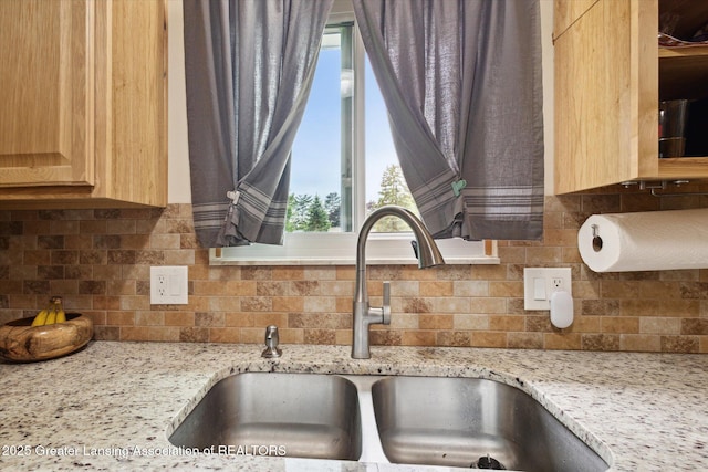 530 S Dibble Blvd, Lansing, MI 48917 - kitchen view of a sink, light brown cabinetry, tasteful backsplash, and light stone counters