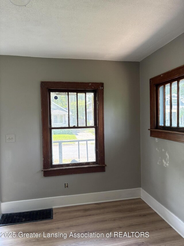 2113 S Rundle Ave, Lansing, MI 48910 - unfurnished room with wood finished floors, baseboards, and a textured ceiling