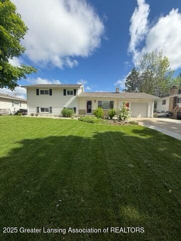 4412 Darron Dr, Lansing, MI 48917 - view of front of home featuring concrete driveway, a garage, and a front yard