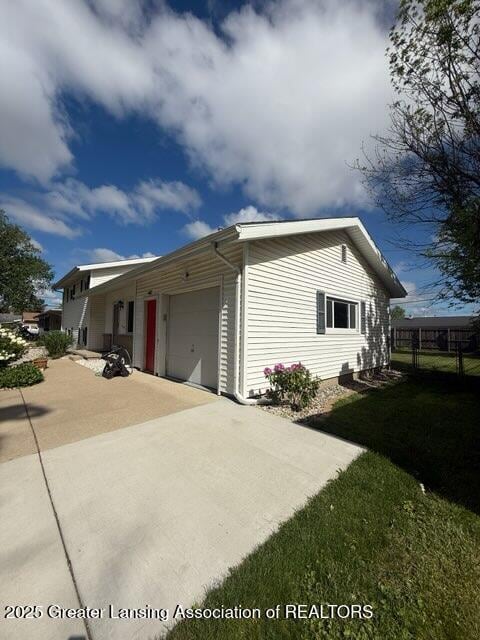 4412 Darron Dr, Lansing, MI 48917 - view of side of property with an attached garage and driveway