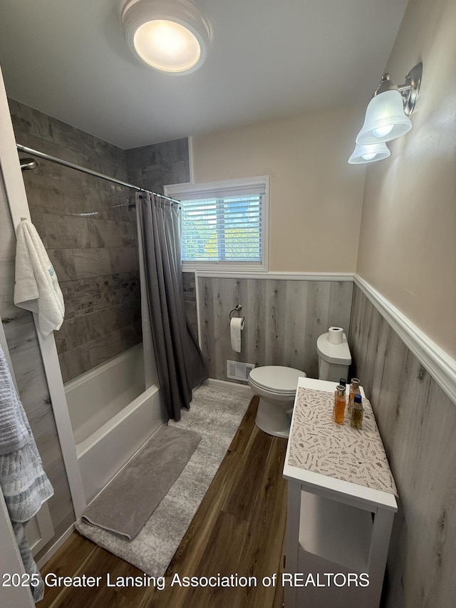 4412 Darron Dr, Lansing, MI 48917 - full bath with wood finished floors, a wainscoted wall, shower / tub combo with curtain, toilet, and vanity