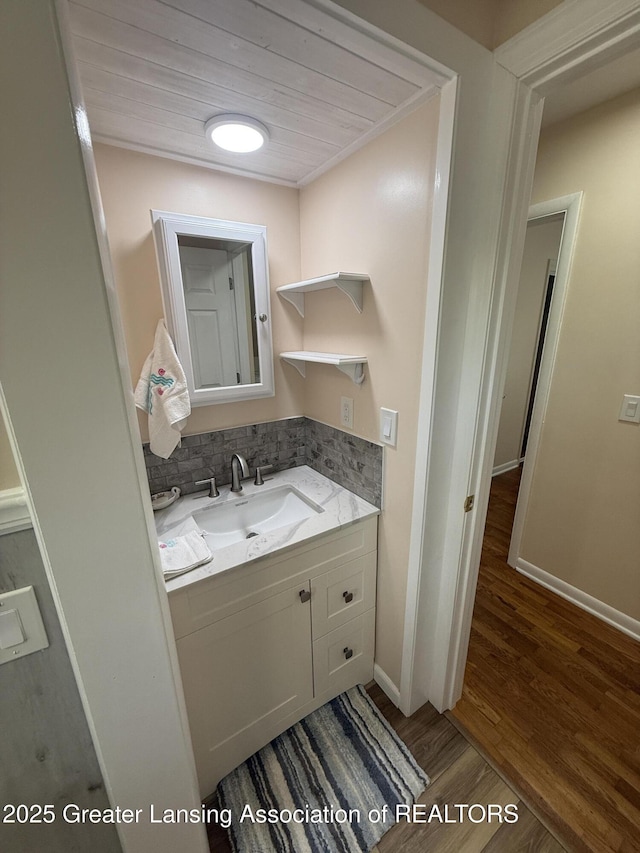 4412 Darron Dr, Lansing, MI 48917 - bathroom with vanity, wood finished floors, baseboards, and tasteful backsplash