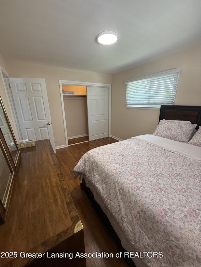 4412 Darron Dr, Lansing, MI 48917 - bedroom featuring dark wood-style floors, a closet, and baseboards