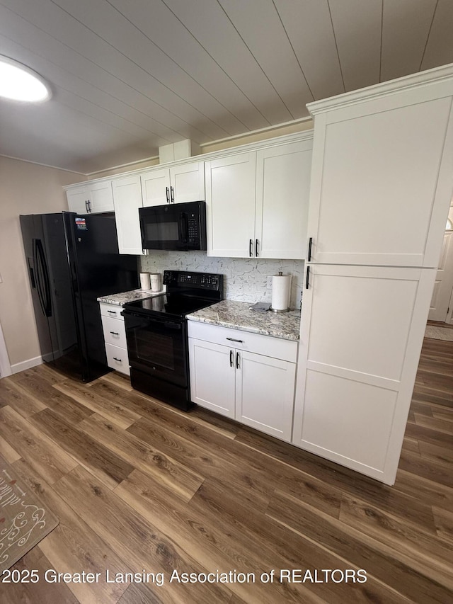 4412 Darron Dr, Lansing, MI 48917 - kitchen with black appliances, white cabinetry, dark wood-type flooring, and light stone counters