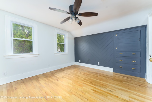 1111 Parkdale Ave, Lansing, MI 48910 - empty room with light wood-type flooring, baseboards, lofted ceiling, and a ceiling fan