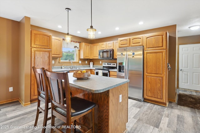 2424 S Canfield Rd, Eaton Rapids, MI 48827 - kitchen featuring stainless steel appliances, light wood-type flooring, a breakfast bar area, pendant lighting, and recessed lighting
