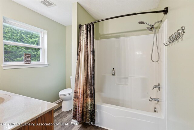 2424 S Canfield Rd, Eaton Rapids, MI 48827 - bathroom with vanity, shower / bathtub combination with curtain, and wood finished floors