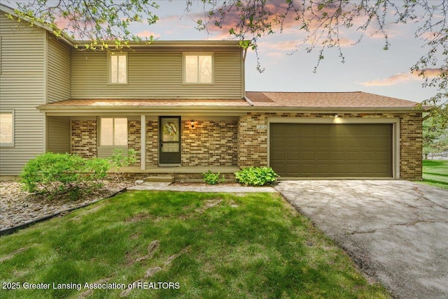1010 Grenoble Cir, Lansing, MI 48917 - view of front of home featuring driveway, a porch, brick siding, a garage, and a yard
