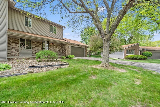 1010 Grenoble Cir, Lansing, MI 48917 - view of front of home featuring driveway, an attached garage, a front yard, and brick siding