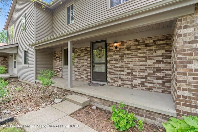 1010 Grenoble Cir, Lansing, MI 48917 - doorway to property featuring covered porch and brick siding