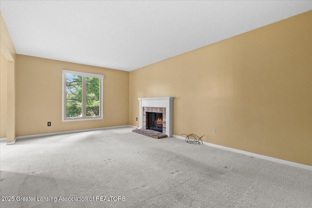 1010 Grenoble Cir, Lansing, MI 48917 - unfurnished living room with carpet flooring, a brick fireplace, and baseboards