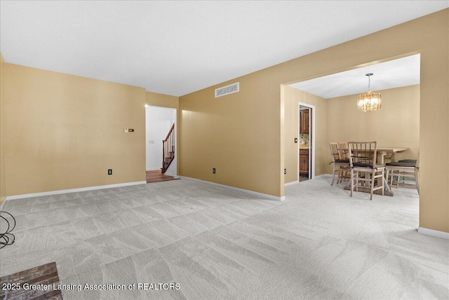 1010 Grenoble Cir, Lansing, MI 48917 - unfurnished living room featuring carpet, stairs, a chandelier, and baseboards