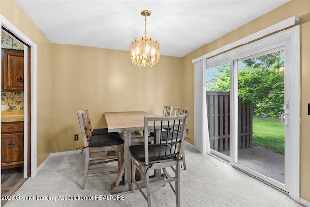 1010 Grenoble Cir, Lansing, MI 48917 - dining room featuring a chandelier, light colored carpet, and baseboards