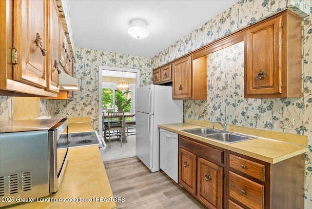 1010 Grenoble Cir, Lansing, MI 48917 - kitchen with wallpapered walls, white appliances, a sink, light wood-style flooring, and light countertops