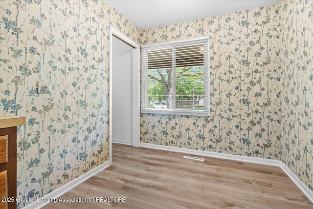 1010 Grenoble Cir, Lansing, MI 48917 - unfurnished room featuring wallpapered walls, wood finished floors, and baseboards