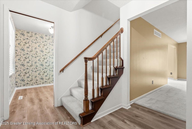 1010 Grenoble Cir, Lansing, MI 48917 - stairway featuring wood finished floors, baseboards, and wallpapered walls