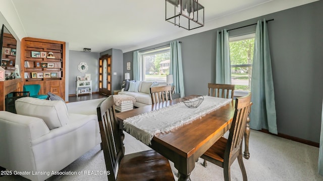 415 W Lawrence Ave, Charlotte, MI 48813 - dining area featuring plenty of natural light, baseboards, a chandelier, and carpet flooring